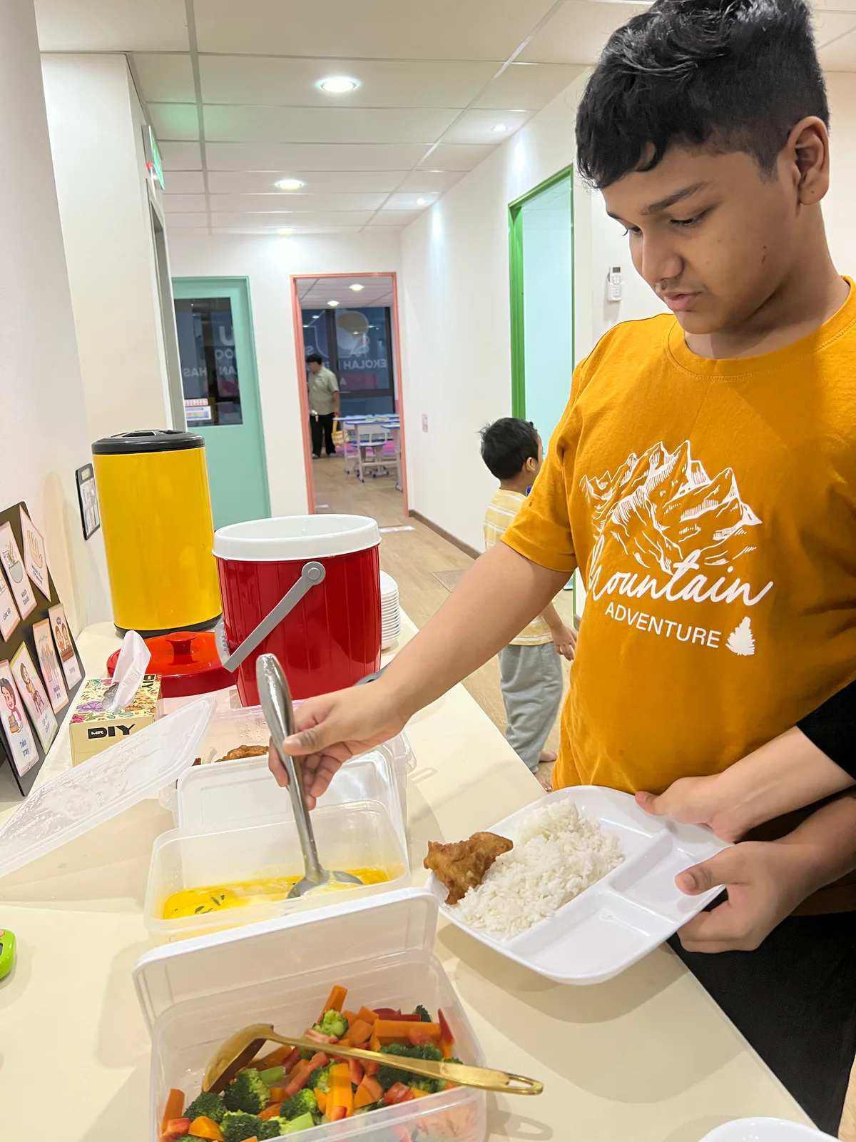 A learner practising independence during a school meal routine