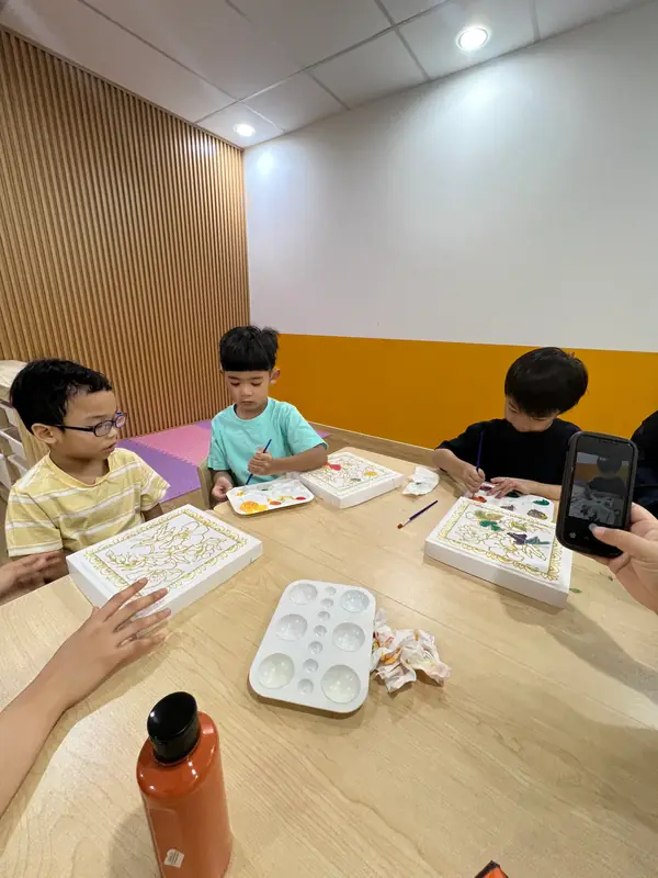 Learners creating artwork together around a shared table