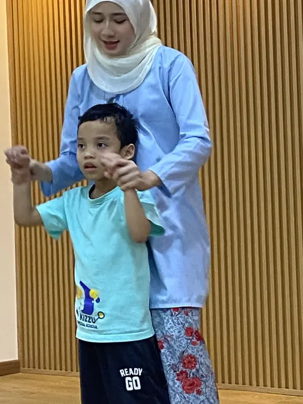 An educator guiding a learner through an active classroom routine